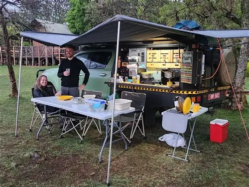 Two tourists camping in Sipi Falls with the Toyota Hilux Overland truck.