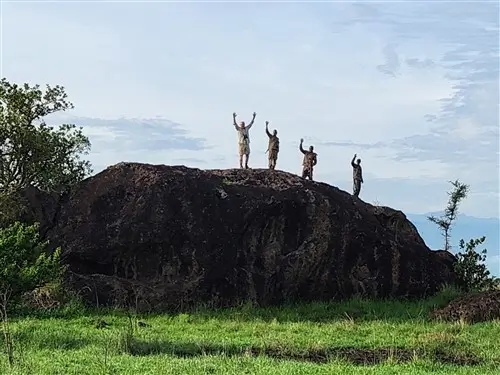 Tourists during safari standing on a big rock in Uganda.